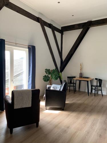 a living room with two chairs and a table at Bed & Breakfast ‘Tuus op Tessel’ in Oosterend
