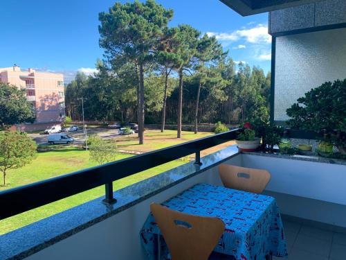 a balcony with a table and chairs and a view of a park at Viana do Castelo, Cabedelo Beach Apartment in Viana do Castelo