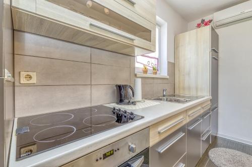 a kitchen with a stove and a sink at Apartments Kardumovic in Poreč