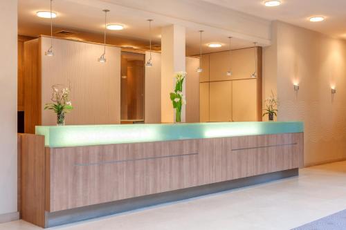 a lobby with a reception desk with a mirror at Citadines Saint-Germain-des-Prés Paris in Paris