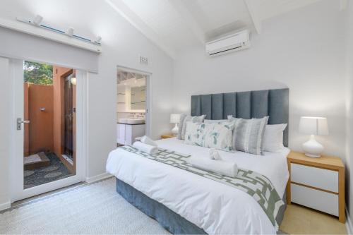 een slaapkamer met een groot bed met een grijs hoofdeinde bij San Lameer Villa 2907 - 2 Bedroom Superior - 4 pax - San Lameer Rental Agency in Southbroom