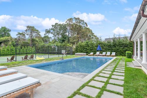 un patio trasero con piscina y canasta de baloncesto en Colonial Hampton Charm, en Southampton