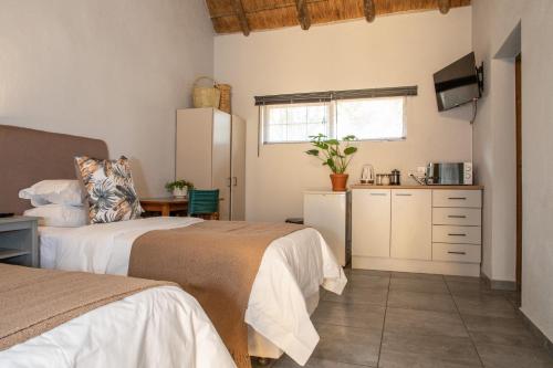 a room with two beds and a kitchen with a refrigerator at El Morado Guest Farm in White River