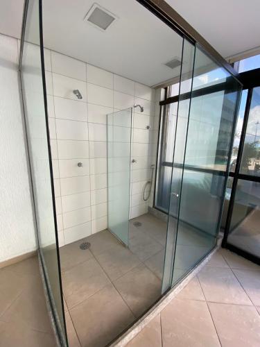 a glass shower stall in a building at Beach Class Internacional apartamento in Recife