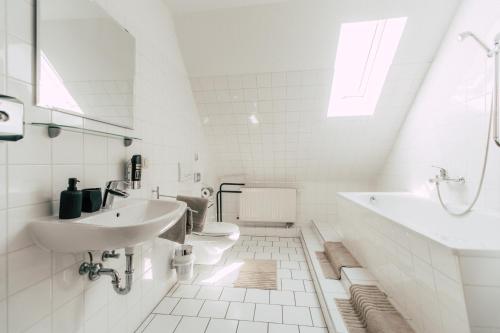 Luga Homes - Rosental في لايبزيغ: حمام ابيض مع دورتين مياه ومغسلة