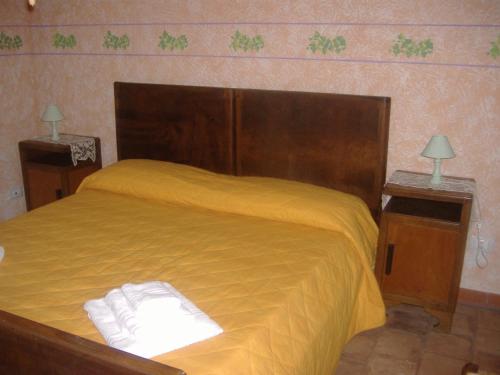 a bedroom with a bed with yellow sheets and two lamps at Agriturismo La.Ti.Mi.Da. in Cassine