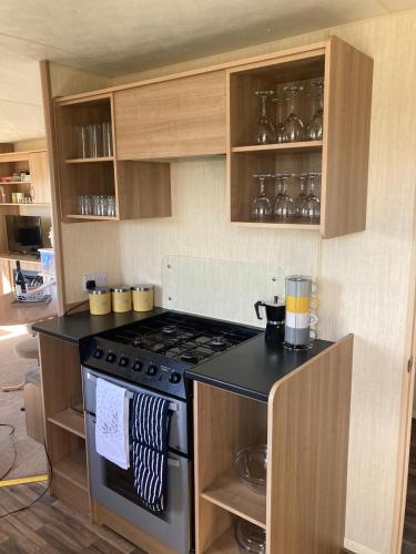 a kitchen with a stove and a counter top at 367 Caravan in Stevenston