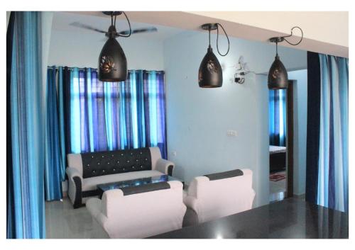 a living room with two chairs and a couch at Kishkindha Wild 3BHK in Rāmnagar