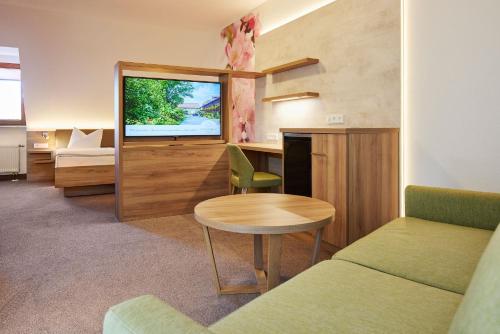 ein Wohnzimmer mit einem Tisch und einem Sofa in der Unterkunft Hotel garni Sonnenhof in Reichenberg