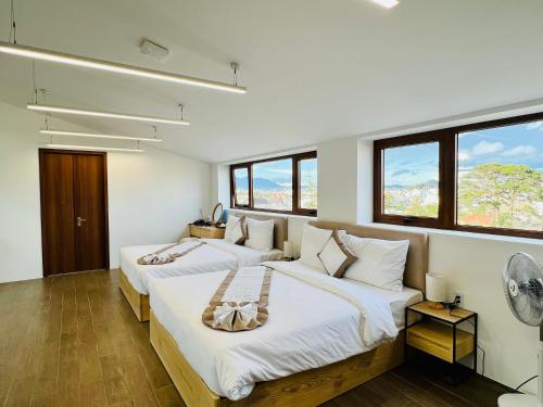two beds in a room with two windows at Lasol Boutique Hotel in Da Lat