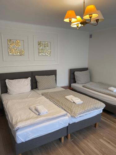 1 dormitorio con cama, sofá y lámpara de araña en Noclegi w Centrum Brodnicy en Brodnica