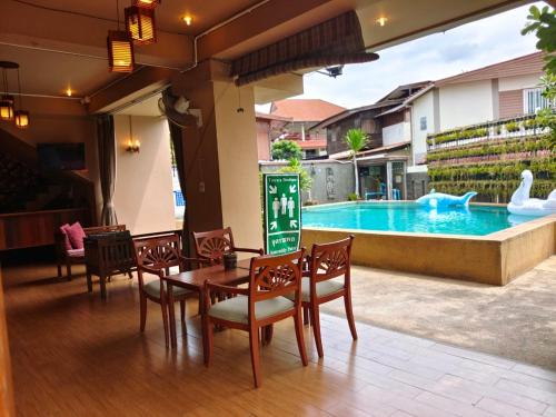 a patio with a table and chairs and a swimming pool at Wualai Boutique by Lanna Oriental in Chiang Mai