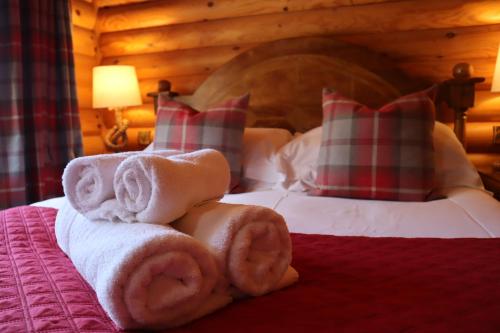 a hotel room with towels and pillows on a bed at Bunnahahbain - Two Bedroom Luxury Log Cabin with Private Hot Tub in Berwick-Upon-Tweed