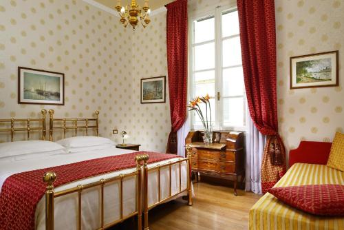 a bedroom with a bed and a window and a chair at Hotel Pendini in Florence