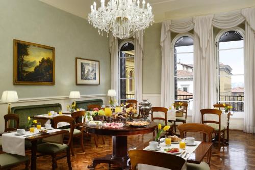 a dining room with tables and chairs and a chandelier at Hotel Pendini in Florence