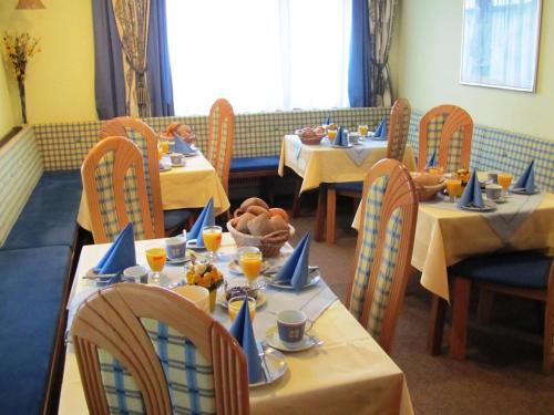 una sala da pranzo con tavoli e sedie con cibo sopra di Apart Garni Lais a Galtür