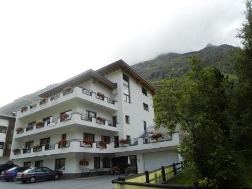a hotel with cars parked in front of a mountain at Apart Garni Lais in Galtür