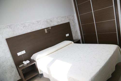 a bedroom with a white bed and a mirror at Nuñez Tomelloso in Tomelloso