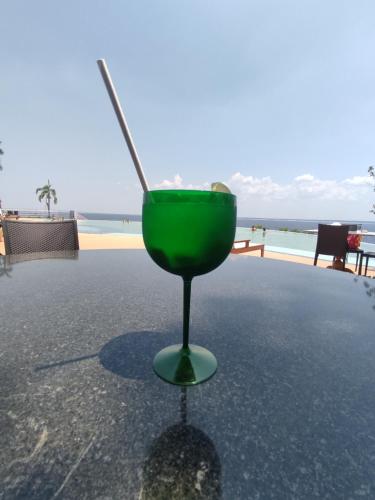 a green drink sitting on a table near the beach at Tropical Executive Flat Vista Incrível para a Orla in Manaus
