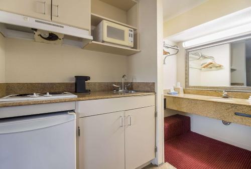 a small kitchen with a sink and a microwave at Suburban Studios Florence I-95 in Florence