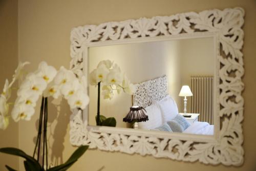 a mirror on a wall with a bed and flowers at Auberge Communale de Carouge in Geneva