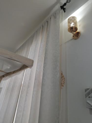 ducha con cortina blanca y luz en Golden Nest en Mombasa