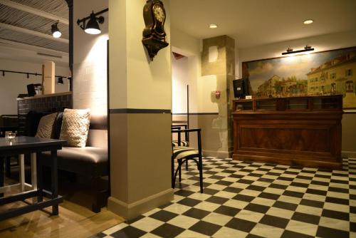 a waiting room with a couch and a table and a stage at Auberge Communale de Carouge in Geneva