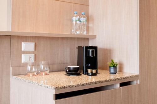a coffee maker and glasses on a counter in a hotel room at The Terrace Hotel Adelaide in Adelaide