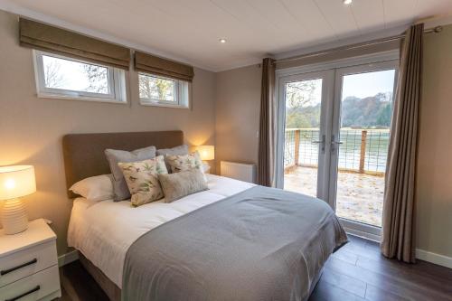 a bedroom with a bed and a large window at Sumners Ponds Fishery & Campsite in Horsham