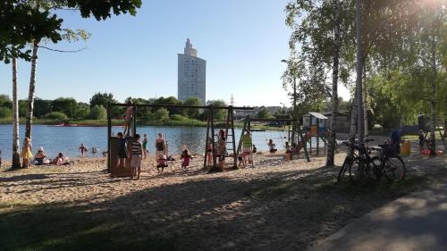 un grupo de personas jugando en un patio de recreo junto a un lago en Cozy apartment near the city centre and Emajõgi, en Tartu