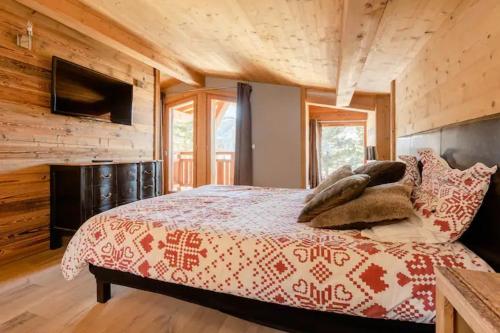 una camera con un letto e un piumone rosso e bianco di Alpine Chalet a Megève