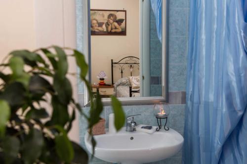 baño con lavabo, espejo y planta en B&B Stupor Mundi, en Altamura