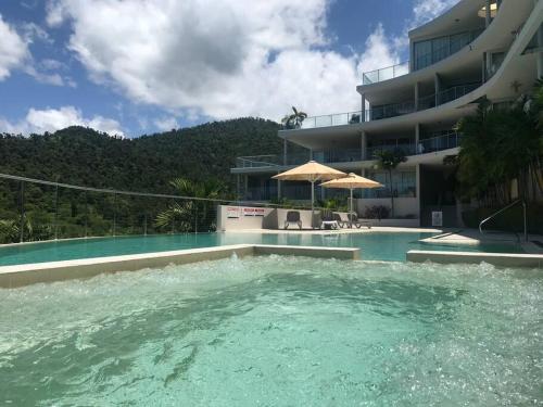 a swimming pool in front of a building at Three A Airlie Seaviews, Pool, Private Spa in Airlie Beach