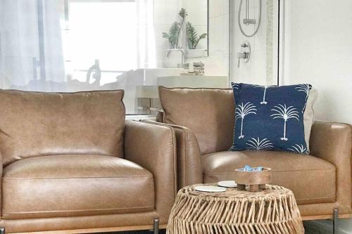 a living room with two chairs and a table at Three A Airlie Seaviews, Pool, Private Spa in Airlie Beach