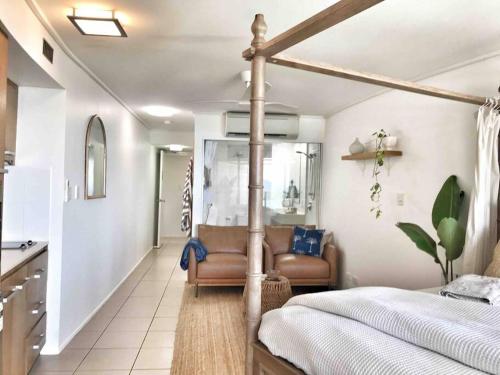 a bedroom with a bed and a living room at Three A Airlie Seaviews, Pool, Private Spa in Airlie Beach