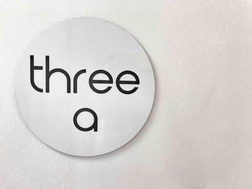 a white sign with the word three a on a wall at Three A Airlie Seaviews, Pool, Private Spa in Airlie Beach