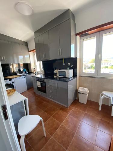 a kitchen with gray cabinets and a tile floor at Al Boa Passagem in Peso da Régua