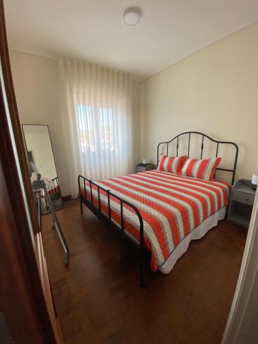una camera con un letto con una coperta a righe rosse e bianche di Al Boa Passagem a Peso da Régua
