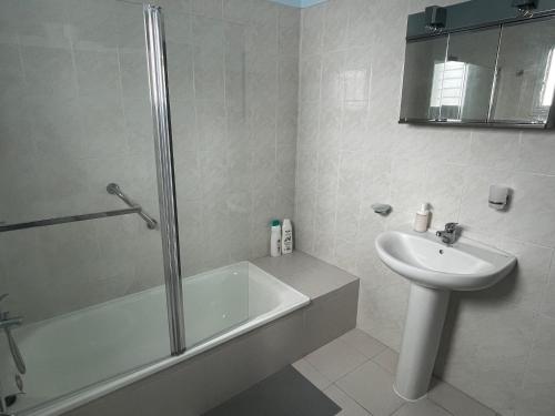 ein weißes Badezimmer mit einem Waschbecken, einer Badewanne und einem WC in der Unterkunft Low Island House in Los Silos