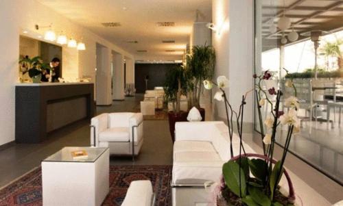a lobby with white couches and flowers in a room at Palazzo Virgilio in Brindisi