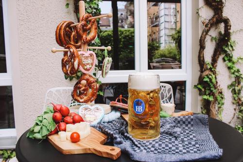 a table topped with a basket of fruit and a glass of beer at Boutique Hotel Atrium München in Munich