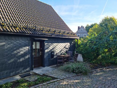 a stone house with a patio with a wooden door at Pilgrims "Frieda" gemütlich Wohnen mit 2 Schlafzimmern in Meschede
