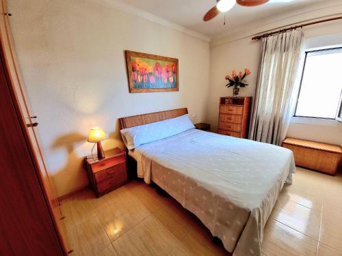 sypialnia z dużym łóżkiem i oknem w obiekcie APARTAMENTO EN PRIMERA LINEA DE PLAYA CON INCREIBLES VISTAS w mieście Santa Pola