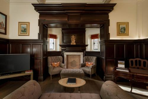 a living room with a fireplace and a tv at The LaLit London - Small Luxury Hotel of the World in London