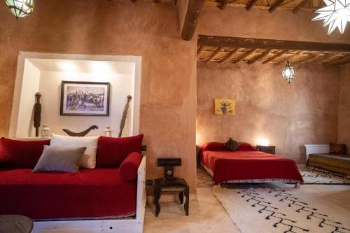 a bedroom with two beds and a couch at Dar Kamar in Ouarzazate