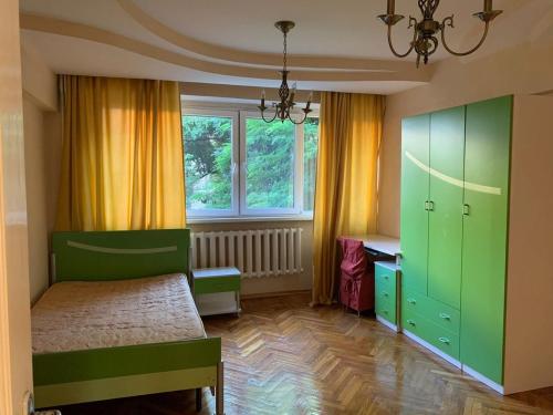 - une chambre avec des armoires vertes, un lit et une fenêtre dans l'établissement Квартира трехкомнатная, à Almaty