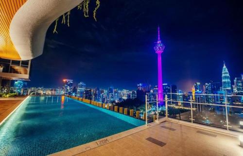 a rooftop pool with a view of the city at night at KLCC View Grand Studio Suites ceylonz in Kuala Lumpur