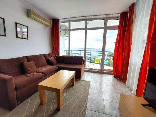a living room with a couch and a table at Vega Village Ap B39 in Sveti Vlas