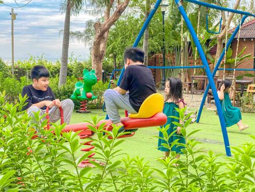 a group of children playing on a playground at Long Hải Channel Beach Resort in Long Hai