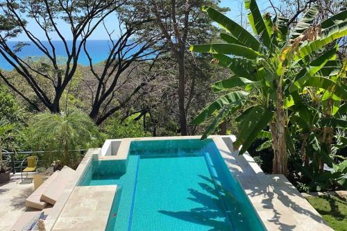 a swimming pool with a view of the ocean at Jungle Villa copa de árbol, oceanview, infinity in Montezuma